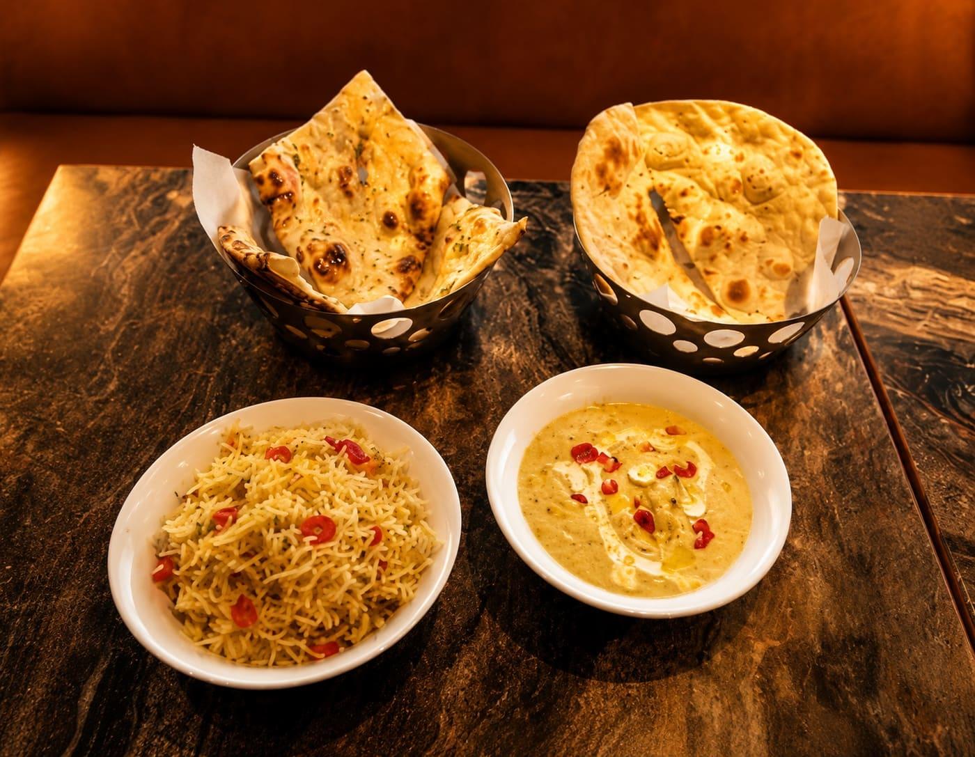 A rich, aromatic Indian curry in a copper bowl under warm light.